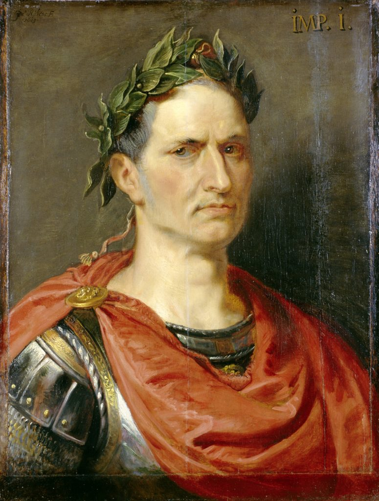 Portrait of a man wearing a laurel and a red cloak over a silver cuirass; the text 'IMP. I.' is in the top-right corner